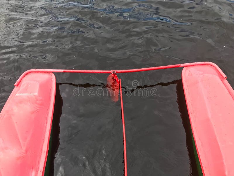 Järnmetallstyrningen rullar i en röd fartygkatamaran i vattnet royaltyfri fotografi Järnmetallstyrningen rullar i en röd fartygkatamaran i vattnet royaltyfri fotografi