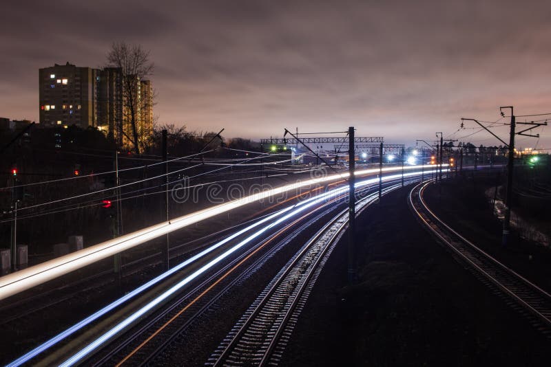 Järnvägsstation på natten med ett övergående drev fotografering för bildbyråer Järnvägsstation på natten med ett övergående drev fotografering för bildbyråer
