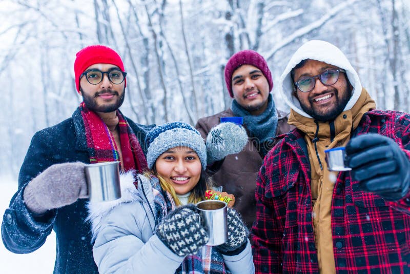 Jóvenes amigos indios felices se calientan con té caliente foto de archivo libre de regalías