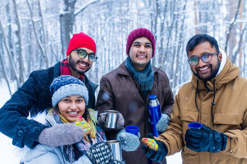 Jóvenes amigos indios felices se calientan con té caliente imagenes de archivo