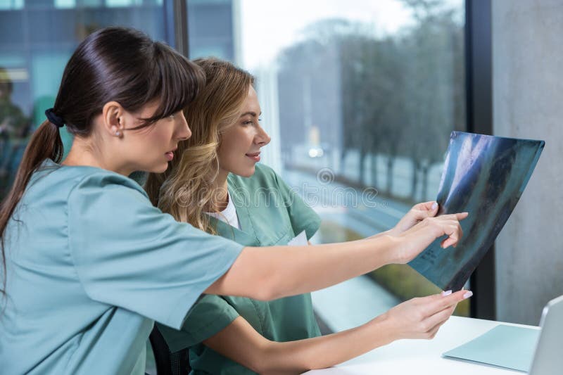Jóvenes doctoras competentes mirando a Xray fotografía de archivo libre de regalías