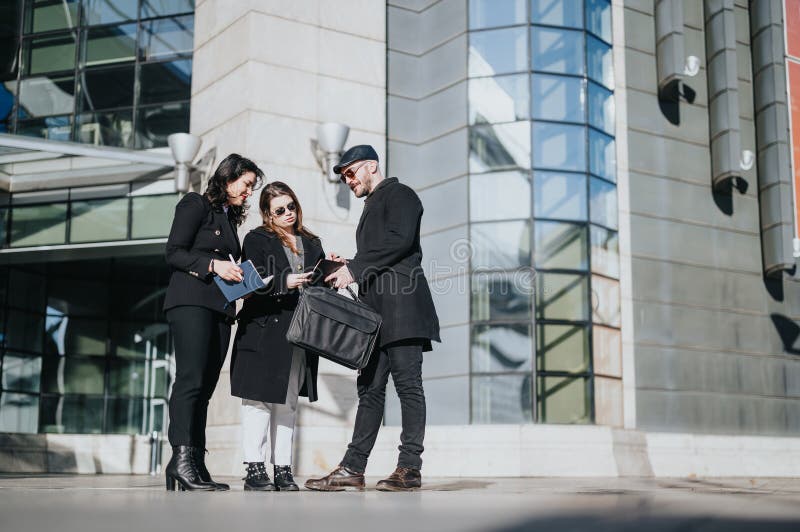 Three young people engaged in a serious business conversation outside a modern urban building, collaborating in the bright daylight. Three young people engaged in a serious business conversation outside a modern urban building, collaborating in the bright daylight.