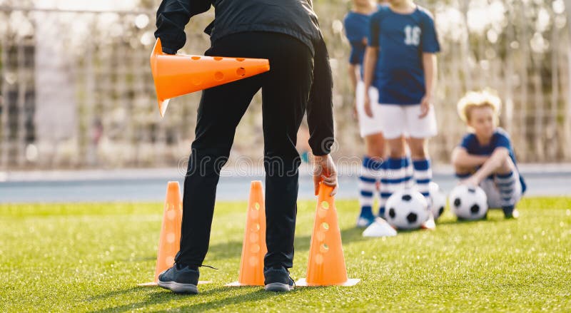 Jóvenes que entrenan a niños en clase de educación física. práctica de fútbol para niños. entrenador preparando equipo de fútbol fotos de archivo