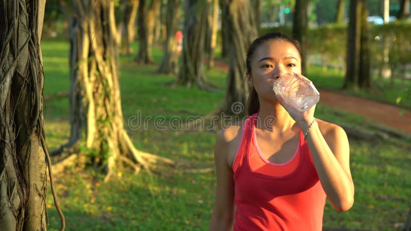 4 k de mulheres asiáticas bebendo água depois de correrem no parque de daan na cidade de taipe