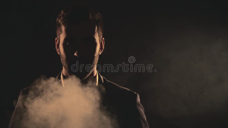 4k fecha o vídeo em câmera lenta do rosto masculino na sombra e fumaça.