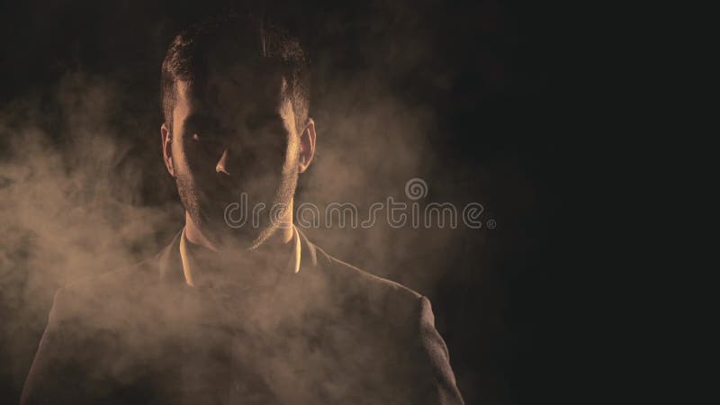 4k fecha o vídeo em câmera lenta do rosto masculino na sombra e fumaça.
