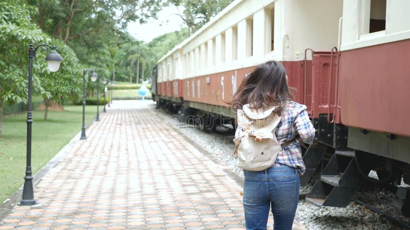 4K Mani d'ondeggiamento della donna turistica asiatica da dire arrivederci in treno di partenza alla stazione ferroviaria Arrived