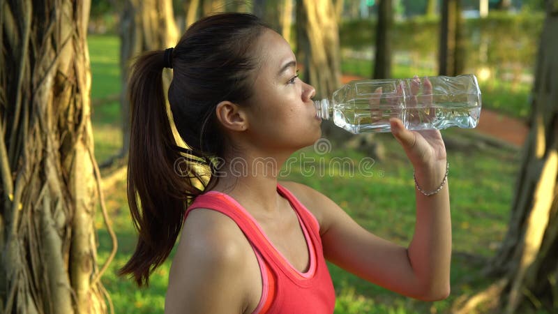 4k, mulher asiática, bebendo água depois de correr no parque de daan, na cidade de taipe