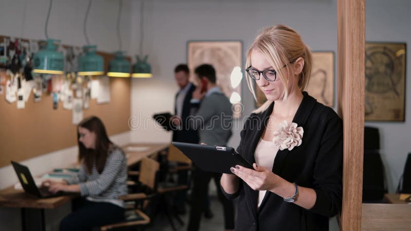 4K onderneemster van het close-up gebruikt de jonge mooie blonde een touchscreen tablet in het moderne startbureau royalty-vrije stock fotografie 4K onderneemster van het close-up gebruikt de jonge mooie blonde een touchscreen tablet in het moderne startbureau royalty-vrije stock fotografie