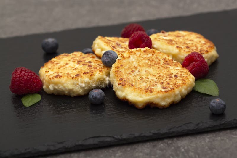 K?sekuchen vom H?ttenk?se H?ttenk?sepfannkuchen oder Klumpenst?ckchen verzierten frische Himbeeren und Blaubeeren lizenzfreie stockbilder K?sekuchen vom H?ttenk?se H?ttenk?sepfannkuchen oder Klumpenst?ckchen verzierten frische Himbeeren und Blaubeeren lizenzfreie stockbilder