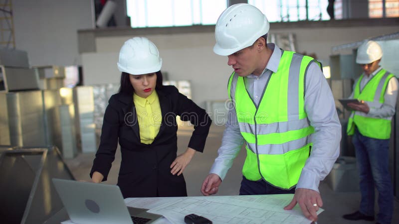 4k Ufny żeński inżynier lub architekt dyskutuje budów zagadnienia z męskimi kolegami używając laptopa airduct