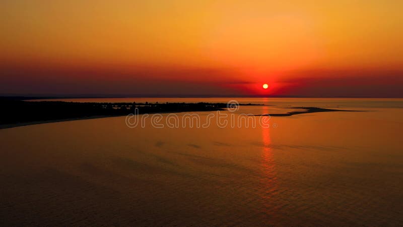 4K UHD Aerial drone view Beautiful sunset over tropical beach with clouds In the middle of the sea