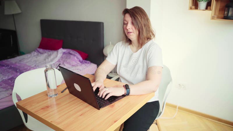 4K video. Young woman using laptop. Girl hands typing at computer keyboard