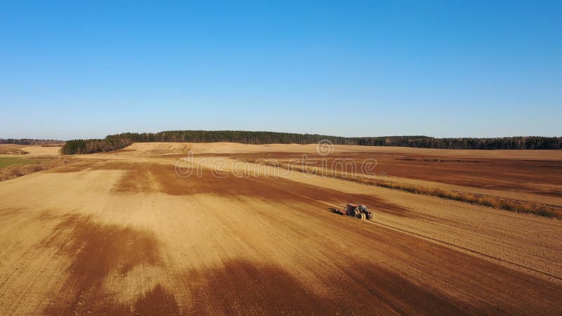 4K Vista aerea del processo di agricoltura: il trattore ara e fa la semina, seminante i raccolti agricoli al campo