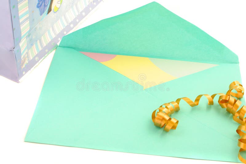 Isolated greeting card inside green envelope stationary with ribbon and gift bag on the side. Isolated greeting card inside green envelope stationary with ribbon and gift bag on the side