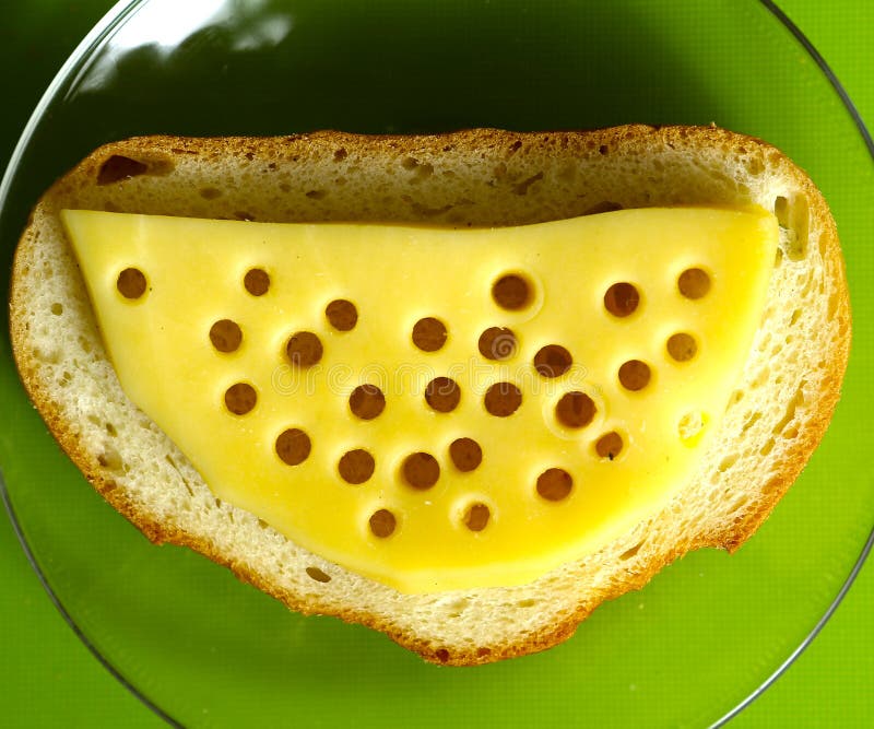 Kaasplak met gaten op dichte omhooggaand van de brood hoogste mening royalty-vrije stock fotografie Kaasplak met gaten op dichte omhooggaand van de brood hoogste mening royalty-vrije stock fotografie