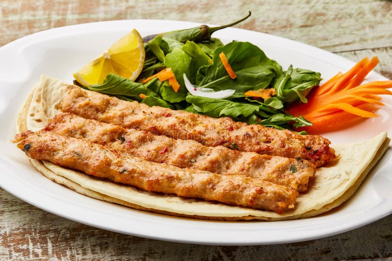Kabab al pollo bq con fetta di limone e insalata servita in un piatto isolato sulla vista da tavola del cibo arabo immagini stock