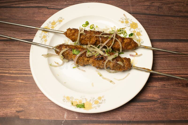 Kabab o shikh kebab tikka servito in un piatto isolato su tavolino di legno vista cibi di spezie indiane fotografia stock