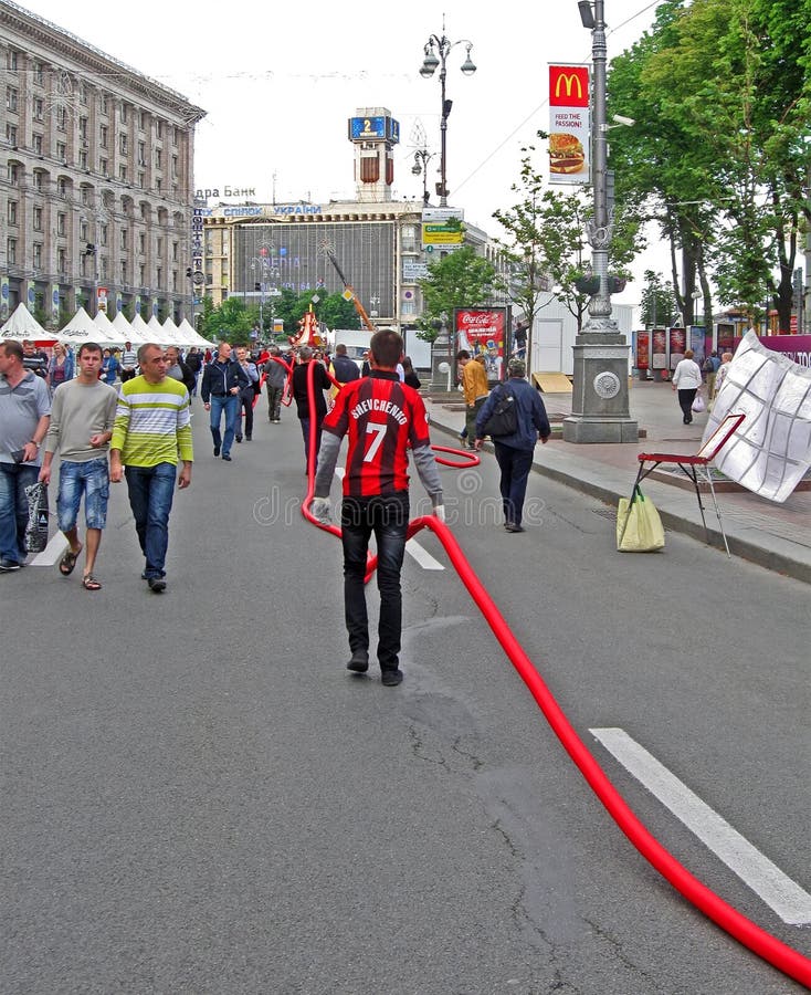 KIEV, UKRAINE - JUNE 02: workers carry the long red cable on Kreshatik street as preparation to EURO 2012 in Kiev, Ukraine on June 02, 2012. EURO 2012 football competition take part in Ukraine and Poland in summer 2012. KIEV, UKRAINE - JUNE 02: workers carry the long red cable on Kreshatik street as preparation to EURO 2012 in Kiev, Ukraine on June 02, 2012. EURO 2012 football competition take part in Ukraine and Poland in summer 2012.