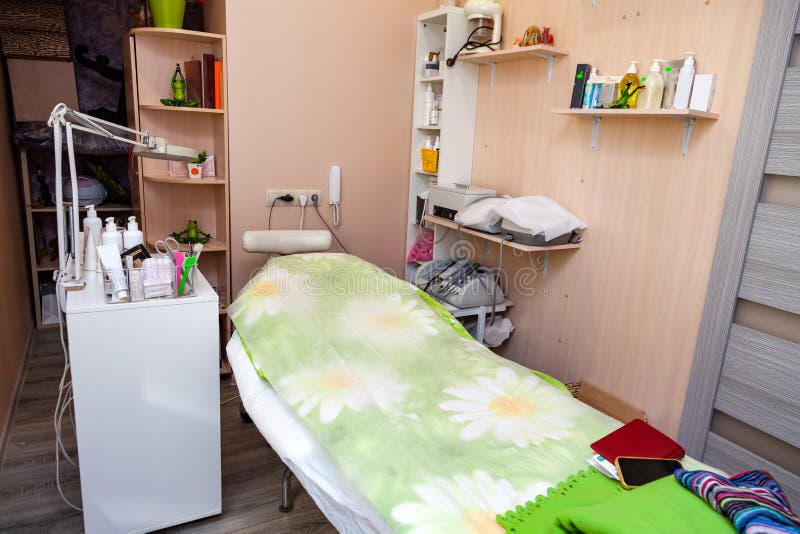 Kabinett Cosmetology mit einer Couch für Massage, eine runde Lampe, ein Gerät für dorsonvalizatsiya Hautpflege und Gesichtsbehand stockbild Kabinett Cosmetology mit einer Couch für Massage, eine runde Lampe, ein Gerät für dorsonvalizatsiya Hautpflege und Gesichtsbehand stockbild