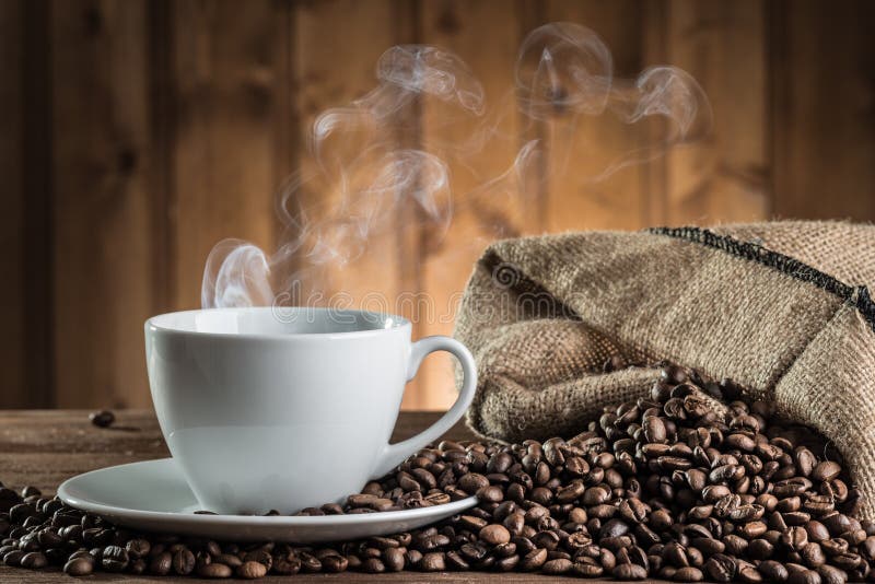 Still life with coffee beans and cup on the wooden background. Still life with coffee beans and cup on the wooden background