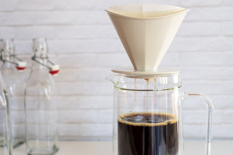 Kaffe ansträngde med kaffefiltret in i den glass kruset, hur till mor royaltyfria bilder Kaffe ansträngde med kaffefiltret in i den glass kruset, hur till mor royaltyfria bilder