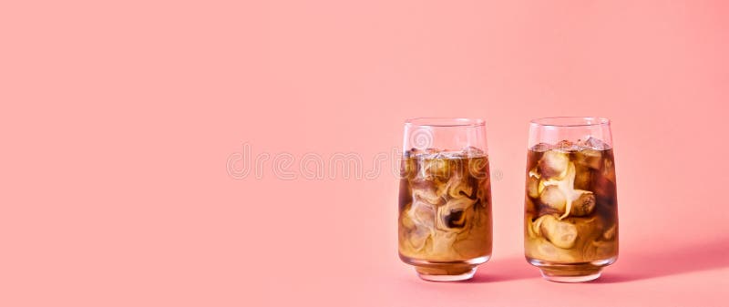 Kaffe med mjölk i höga glas på rosa bakgrund. Koncept för att fräscha sommardryck royaltyfri fotografi