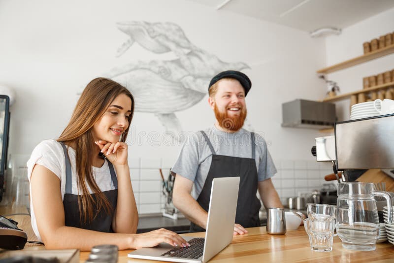 Kaffeaffärsidé - det lyckliga barnet kopplar ihop företagsägare av den lilla coffee shop som arbetar och hyvlar på bärbara datorn arkivfoton Kaffeaffärsidé - det lyckliga barnet kopplar ihop företagsägare av den lilla coffee shop som arbetar och hyvlar på bärbara datorn arkivfoton