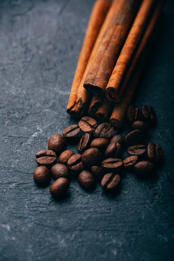 Kaffebönor och kanel på svart bakgrund