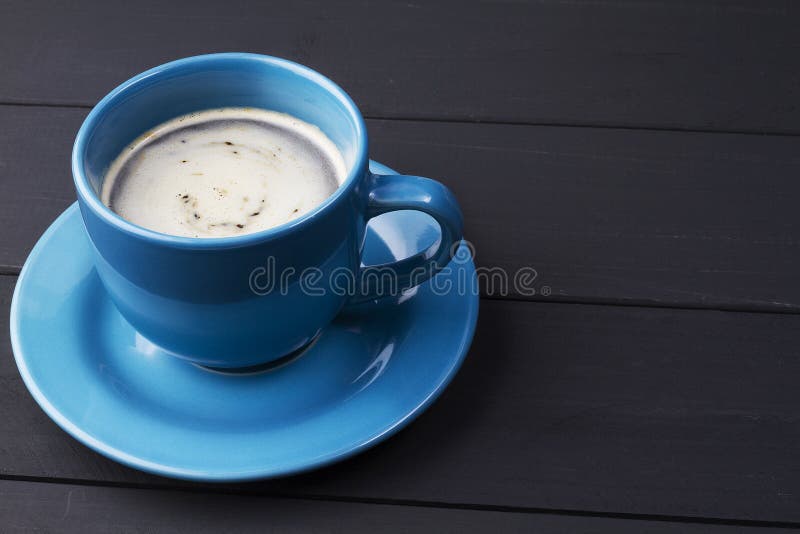 Kaffee in der blauen Schale mit zusammenpassendem Teller auf schwarzem hölzernem Hintergrund stockbild Kaffee in der blauen Schale mit zusammenpassendem Teller auf schwarzem hölzernem Hintergrund stockbild