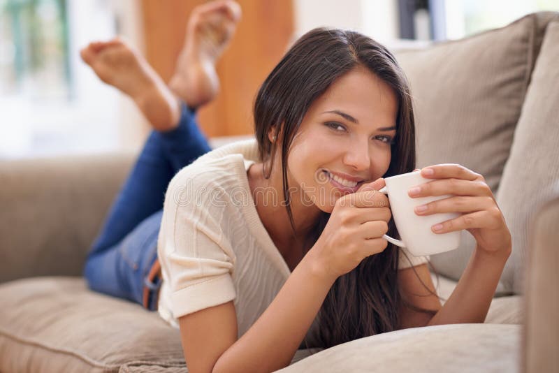 Kaffee-Frau und Portrait auf Sofa zum Entspannen Wochenende in der Wohnung für ruhigen Urlaub Ruhe oder Urlaub. weibliche Person lizenzfreie stockfotografie