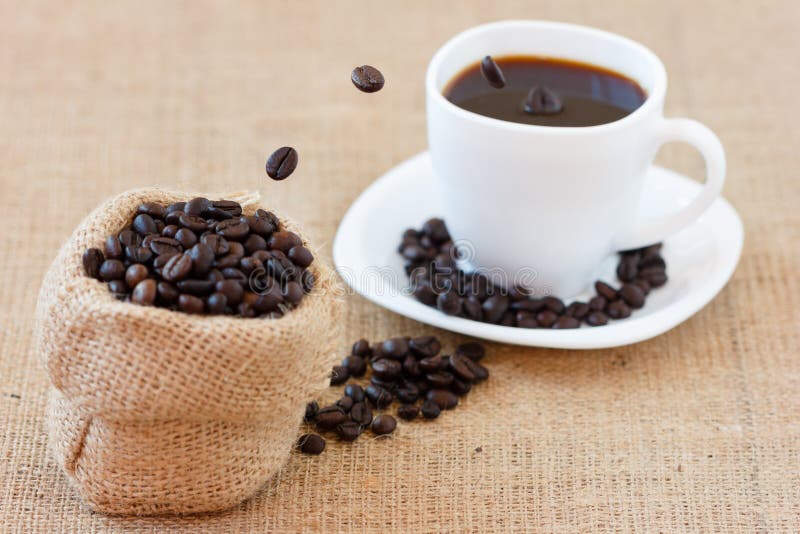Kaffeebohnen, die in weiße Schale springen lizenzfreie stockfotografie Kaffeebohnen, die in weiße Schale springen lizenzfreie stockfotografie