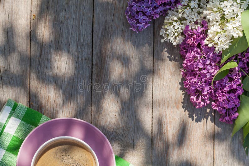 Kaffeetasse und bunte lila Blumen auf Gartentisch lizenzfreies stockbild Kaffeetasse und bunte lila Blumen auf Gartentisch lizenzfreies stockbild