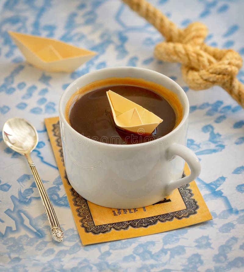 Kaffeetasse und Papierboot stockbild Kaffeetasse und Papierboot stockbild