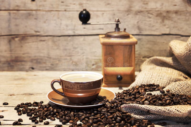Coffee cup, beans and grinder on vintage wooden background. Coffee cup, beans and grinder on vintage wooden background