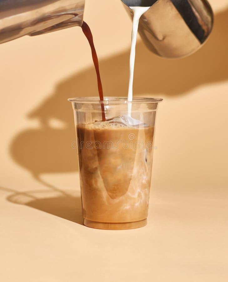 Kaffemjölk i en plastkopp inuti ett café royaltyfria bilder