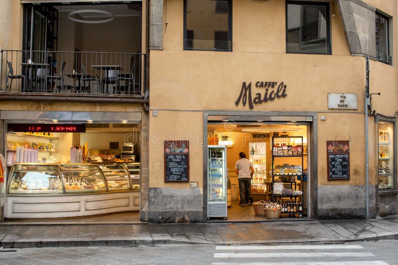 Kafé precis efter att ha öppnat med en leverans till en arbetare, några lådor med blomning royaltyfria bilder