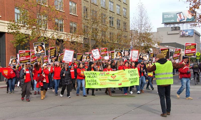 Oakland, CA - Dec 17, 2019: Unidentified Health Care workers protesting marching down Broadway to ONE Kaiser. Among concerns are low wages, high pay for Kaiser executives and staffing shortages. Oakland, CA - Dec 17, 2019: Unidentified Health Care workers protesting marching down Broadway to ONE Kaiser. Among concerns are low wages, high pay for Kaiser executives and staffing shortages