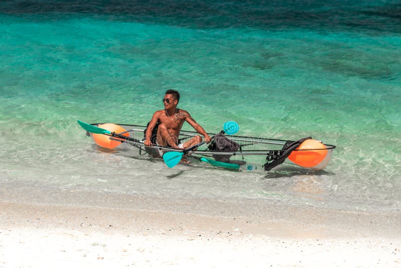 Kajak di vetro con un mare di nuoto del turchese dell'uomo locale in Bora Bora, Tahiti - gennaio 2018 fotografia stock Kajak di vetro con un mare di nuoto del turchese dell'uomo locale in Bora Bora, Tahiti - gennaio 2018 fotografia stock