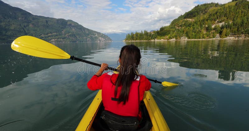 Kajakande i squamish paddling i kayak i howe låter en fjord omgiven av berg. människor som lever friska stock video