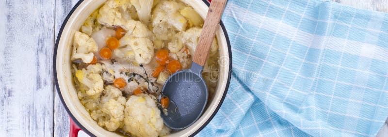 Kalafior gotujący w czerwieni obsady żelazie Błękitny ręcznik Uwalnia przestrzeń dla teksta sztandar fotografia stock Kalafior gotujący w czerwieni obsady żelazie Błękitny ręcznik Uwalnia przestrzeń dla teksta sztandar fotografia stock