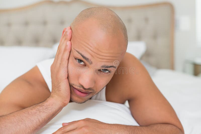 Kale mens die aan tandpijn in bed lijden royalty-vrije stock foto Kale mens die aan tandpijn in bed lijden royalty-vrije stock foto