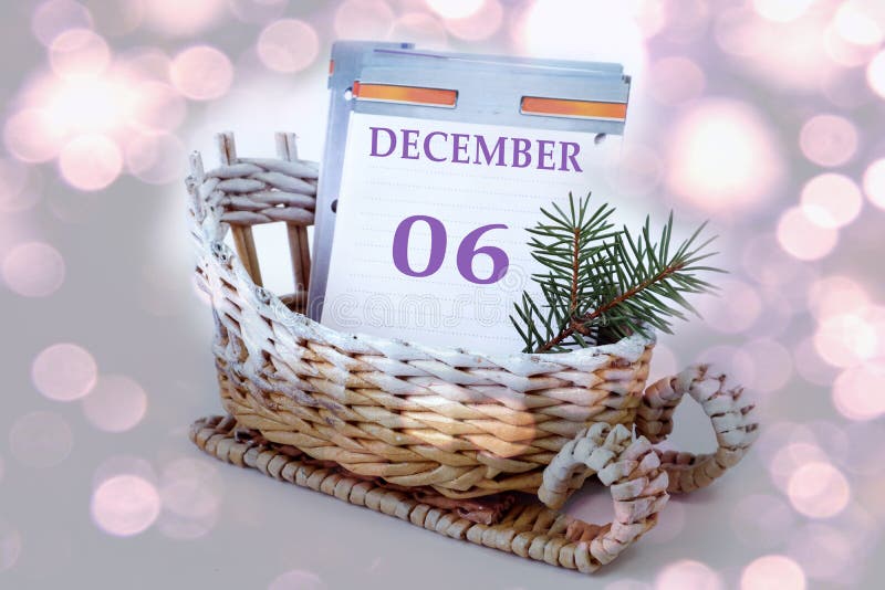 Calendar for December 6: leaves of a calendar with the name of the month, numbers 0 and 6 in a decorative sleigh, a spruce branch on a light background, close-up, bokeh / emmet b vs code. Calendar for December 6: leaves of a calendar with the name of the month, numbers 0 and 6 in a decorative sleigh, a spruce branch on a light background, close-up, bokeh / emmet b vs code.