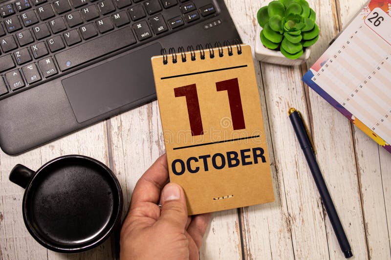 White block calendar present date 11 and month October on wood background. White block calendar present date 11 and month October on wood background