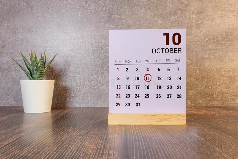 White block calendar present date 11 and month October on wood background. White block calendar present date 11 and month October on wood background