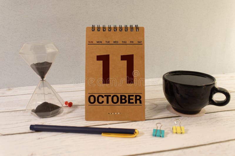 White block calendar present date 11 and month October on wood background. White block calendar present date 11 and month October on wood background