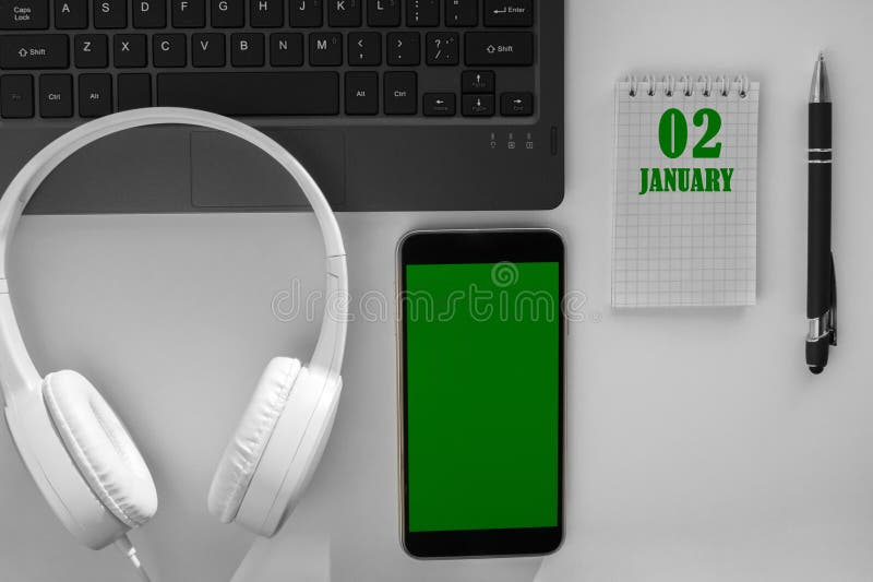 calendar date on a light background of a desktop and a phone with a green screen. January 2 is the second day of the mont. calendar date on a light background of a desktop and a phone with a green screen. January 2 is the second day of the mont.