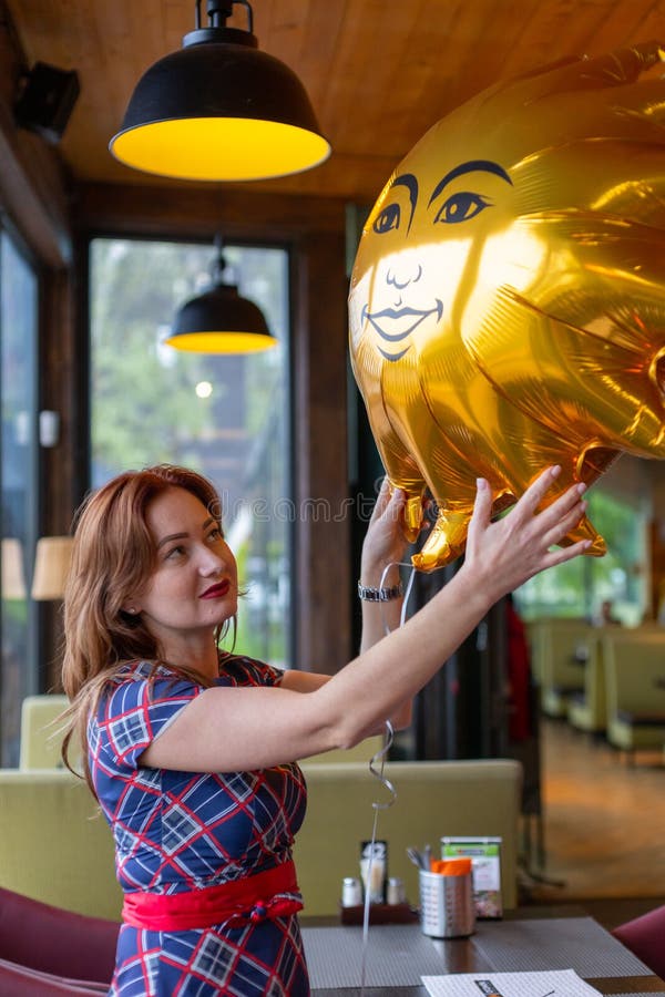 Kaliningrad, Russia - May 13, 2019: Beautiful girl take a gift balloon at her anniversary day at city restaurant stock image Kaliningrad, Russia - May 13, 2019: Beautiful girl take a gift balloon at her anniversary day at city restaurant stock image