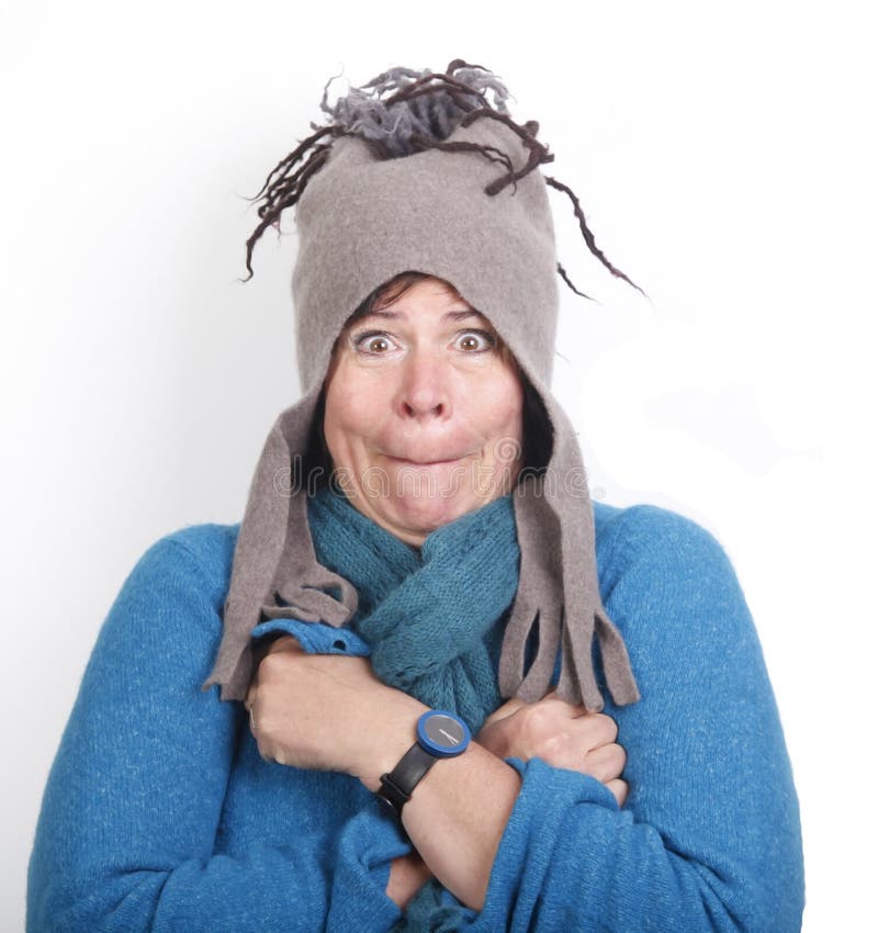 Shivering middle aged woman in funny felt cap and in blue sweater. Shivering middle aged woman in funny felt cap and in blue sweater