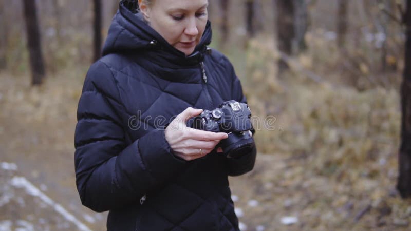 Kamera w rękach fotograf patrzeje położenia i brać zdjęcia jesień lasowy filmowy strzał, wolny zdjęcie wideo Kamera w rękach fotograf patrzeje położenia i brać zdjęcia jesień lasowy filmowy strzał, wolny zdjęcie wideo